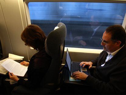 Viajeros trabajando con el ordenador en el AVE.