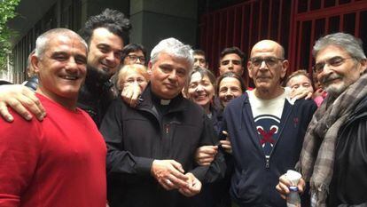 El cardenal Konrad Krajewski, junto a algunos de los vecinos del edificio ocupado al restituyó la luz el sábado.