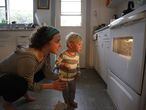 Una madre observa junto a su hijo el horno.