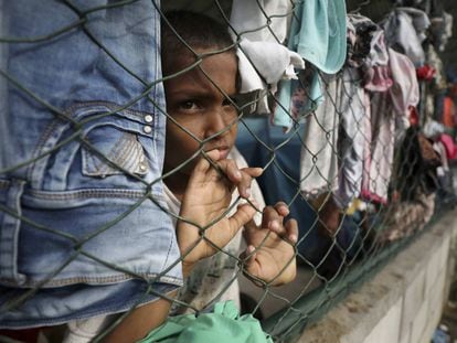Un niño mira a través de una cerca en un refugio instalado en un centro comunitario en Arauquita, Colombia, el jueves 25 de marzo de 2021, en la frontera con Venezuela.