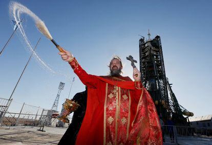 Un sacerdote ortodoxo lleva a cabo una bendición frente a la nave espacial Soyuz MS-04 antes de su próximo lanzamiento, en el cosmódromo de Baikonur, en Kazajistán.