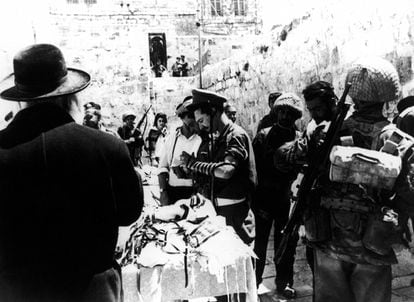 Un judío ortodoxo presta prendas de oración y filacterias para que los soldados israelíes recen en el Muro de las Lamentaciones de Jerusalén, el 8 de junio de 1967, en la Guerra de los Seis Días.
