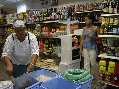 El colmado Afrolatino está especializado en comidas de países latinoamericanos. En la foto, una mujer seleccionando productos a granel.