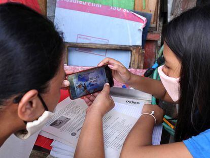 Christine Mae Escobido (derecha), de 11 años, y su madre Warlyn Langit estudian Geografía con la ayuda de un móvil en el barrio de Santa Ana, en Manila. 