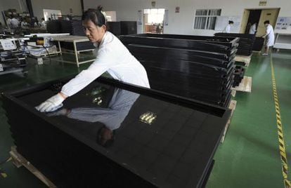 Una empleada limpia paneles solares reci&eacute;n fabricados en la ciudad china de Hefei.