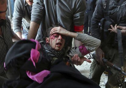 Un herido del ejercito libre sirio es llevado por otros combatiente fuera de la base del ejercito sirio donde fue alcanzado por un francotirador en el barrio de Arabeen.