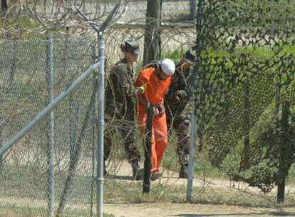 Un detenido es trasladado por dos soldados para ser interrogado en el campo de detención de EE UU en Guantánamo.