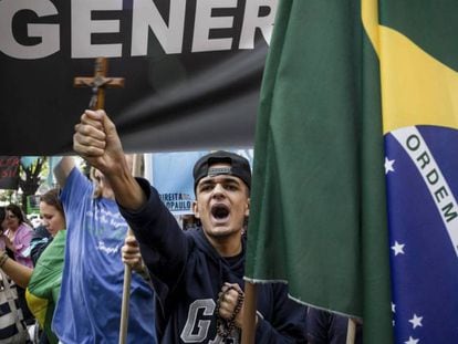 Un joven protesta contra la filósofa feminista Judith Butler, el pasado 9 de noviembre en São Paulo. En vídeo, perfil de Jair Bolsonaro, diputado y candidato presidencial de extrema derecha.