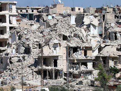 Varios civiles pasan frente a edificios dañados en el barrio de Bani Zeid, en Alepo, este viernes.