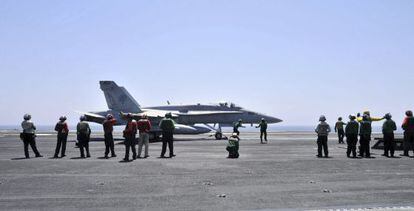 Miembros de la Marina de EE UU guiando a un avión Hornet F/A 18