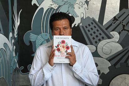 El escritor Noé Zavaleta posa para un retrato con una copia de su libro 'Las buscadoras'.