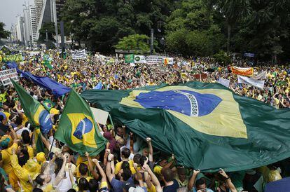 Los manifestantes sostienen una bandera brasileña durante la marcha.