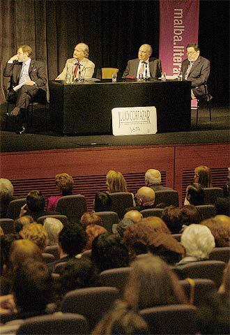 En la mesa y de izquierda a derecha, Juan Luis Cebrián, Carlos Fuentes, Tomás Eloy Martínez y el presentador del coloquio dedicado a Cortázar.