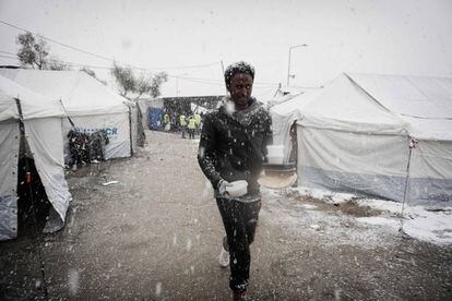 Un migrante camino bajo una nevada en un campamento de la isla de Lesbos, en Grecia.