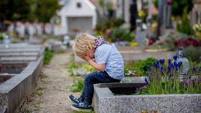 Un niño llora en un cementerio.