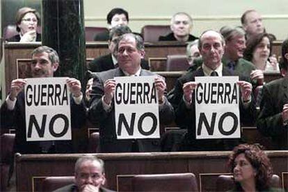 Gaspar Llamazares, Felipe Alcaraz y Francisco Frutos muestran carteles contra la guerra.