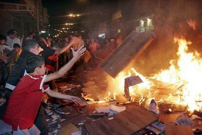 Decenas de seguidores de Fatah, algunos de ellos adolescentes, queman documentos y muebles de una oficina de Hamás en Hebrón.