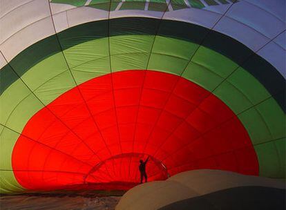 Un empleado de Green Aerostación supervisa el inflado del globo antes de un viaje.