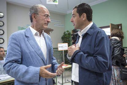El presidente del PP andaluz, Juanma Moreno (derecha), tras ejercer su derecho al voto, dialoga con el candidato a la alcaldía de Málaga, Francisco de La Torre.