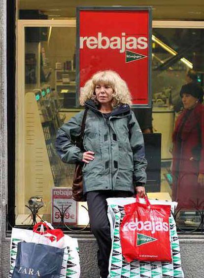 Una mujer con sus compras de rebajas en la calle de Preciados.