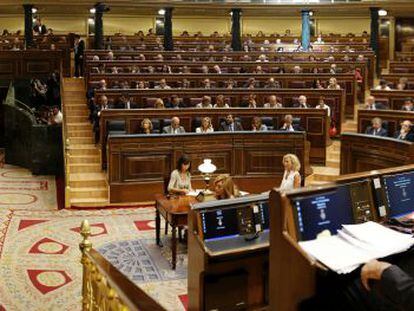 Rajoy (derecha) sigue una intervención de Zapatero en el Congreso.