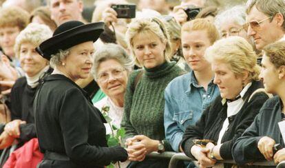 La reina Isabel de Inglaterra saluda a los ciudadanos que hacen cola ante el palacio de St James, en Londres, para firmar en el libro de condolencias por la muerte de la princesa Diana De Gales.