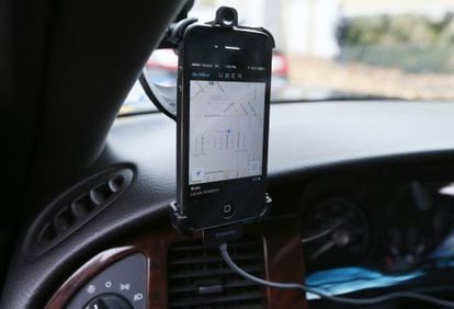 Un móvil instalado en un coche muestra la aplicación de Uber