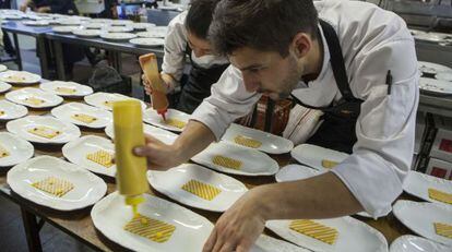 Dos estudiantes cocinan bajo la dirección de los hermanos Roca.