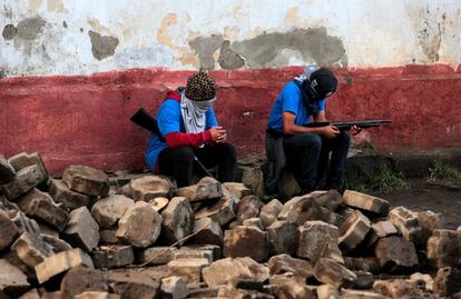 Dos miembros de grupos armados que apoyan al gobierno descansan en una barricada tras los enfrentamientos con los manifestantes de Monimbó en Masaya (Nicaragua), el 17 de julio de 2018.