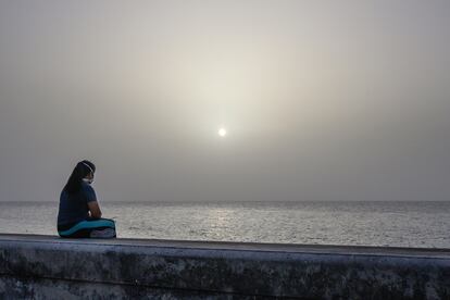 Una mujer contempla la tormenta de arena del Sáhara desde el Malecón de La Habana, Cuba.