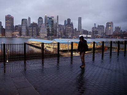 Un hombre camina por una calle desierta ante el 'skyline 'de Manhattan.