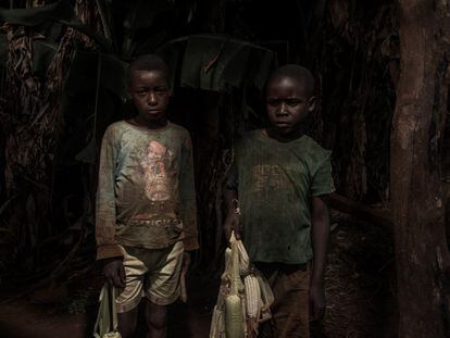 Dos niños de Sanga vuelven del campo cargados de maíz.


