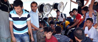 Un grupo de inmigrantes indocumentados se aproxima en un bote de la guardia de salvamento griega a la isla de Creta. 