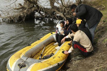 Una familia utiliza un bote para cruzar el río Evros, el 1 de marzo. Autobuses, que nadie sabe quién ha fletado, van distribuyendo a los migrantes en pequeños grupos a lo largo de unos 25 kilómetros de frontera.