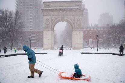 Una familia juega en la nieve en Square Park, Nueva York.