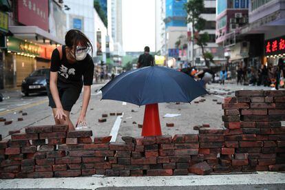 Un manifestante construye un muro en la calle con ladrillos del pavimento, durante las manifestaciones en el distrito de Wanchai en Hong Kong.
