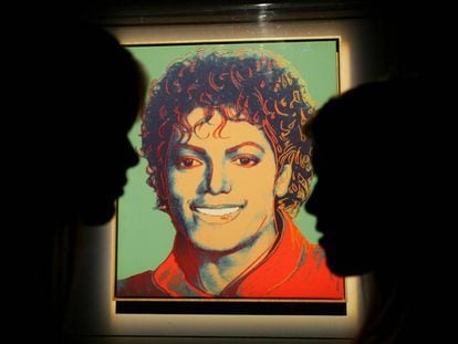 Dos visitantes frente al retrato de Michael Jackson hecho por Andy Warhol, expuesto en 2009 en en estadio O2 de Londres, donde Michael iba a dar una serie de conciertos antes de morir. 