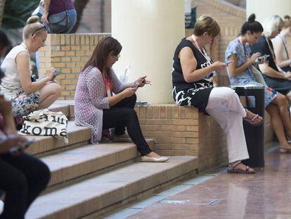 Un grupo de asistentes a un congreso en Sevilla usa sus dispositivos móviles conectados a la wifi del centro.