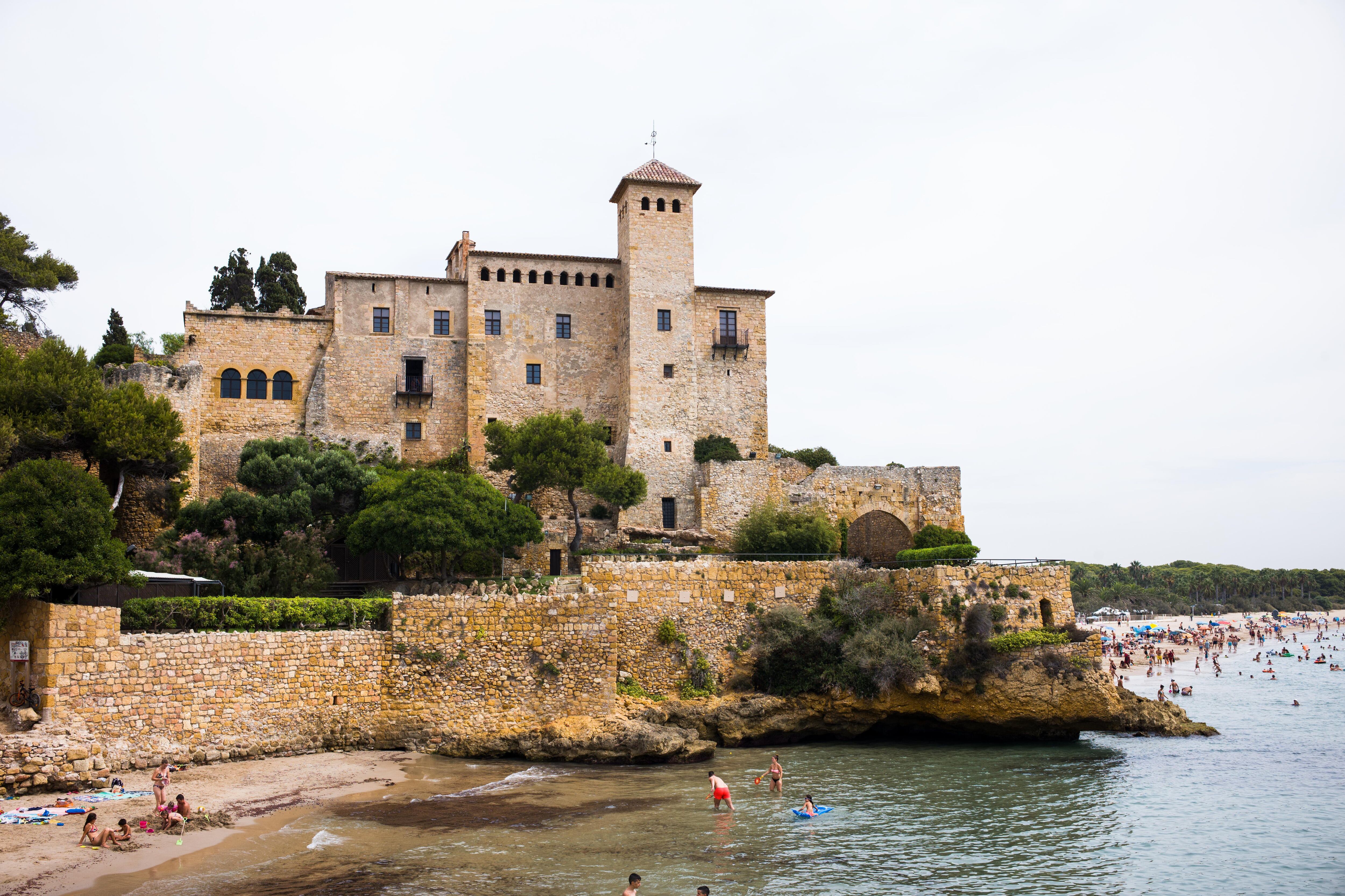 Bañistas en la playa de Altafulla, junto al castillo de Tamarit (Tarragona).