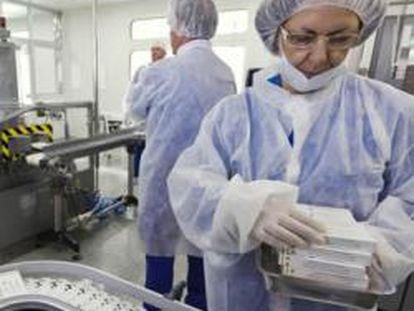 Una trabajadora en un laboratorio que prepara vacunas contra la gripe N1H1