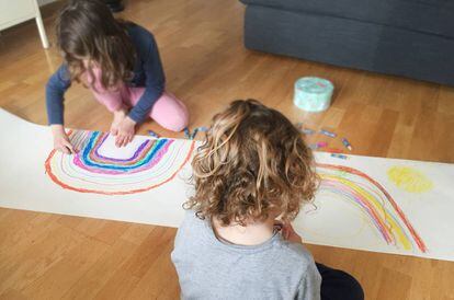 Dos niños dibujan dos arcoíris solidarios.