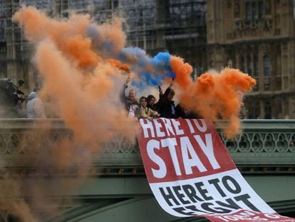 Un grupo de personas sostiene bengalas de humo mientras coloca una pancarta en el puente de Westminster, en Londres, este viernes. En vídeo, tres españoles residentes en Londres expresan sus sentimientos sobre la salida del Reino Unido de la Unión Europea.