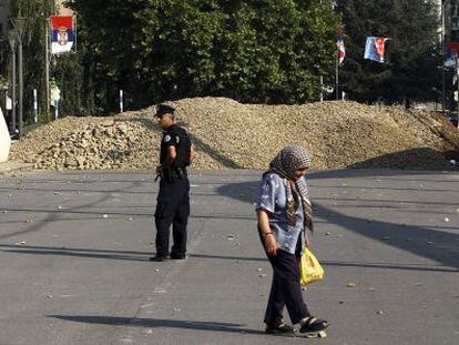 Una mujer camina junto al controvertido puente de Mitrovica.