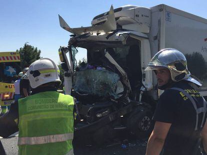 Unos bomberos, delante del cami&oacute;n siniestrado en la AP-6.