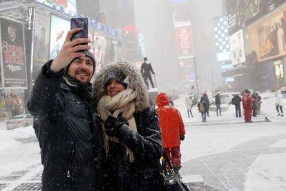 Una pareja se hace una foto entre la nieve en Times Square, Nueva York.