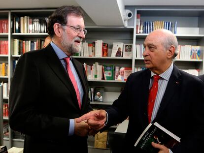 El expresidente del Gobierno Mariano Rajoy conversa con el exministro del Interior Jorge Fernández Díaz en una presentación de un libro en octubre de 2019 en Madrid.