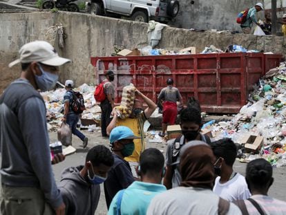 Un grupo de personas se junta frente a un contenedor de basura en el barrio de Petare, en Caracas, el 4 de agosto.