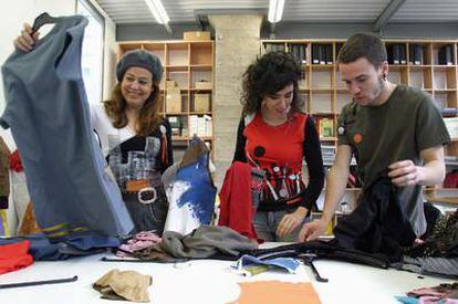 Dos becarios trabajando con una diseñadora de moda.