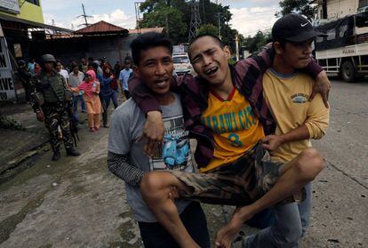 Un residente, desplazado por los combates entre los soldados filipinos y el grupo yihadista, es ayudado a ser evacuado en la ciudad de Marawi.