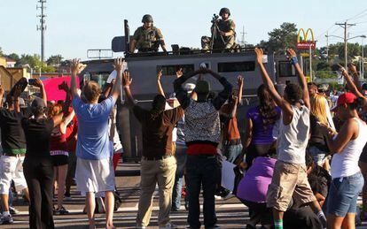 Manifestantes ante un veh&iacute;culo blindado de la polic&iacute;a en Ferguson, Misuri